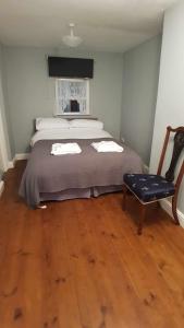 哈佛威斯特Puffin Place,Lloyd House的一间卧室配有一张大床和一把椅子