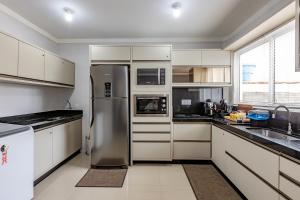 巴拉奈里奥-坎布里乌Apartamento 2 quartos com Spá Expocentro Praias的厨房配有不锈钢冰箱和白色橱柜