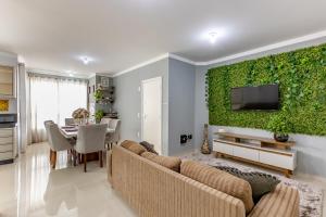 巴拉奈里奥-坎布里乌Apartamento 2 quartos com Spá Expocentro Praias的带沙发和绿色墙壁的客厅