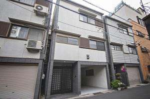 大阪Tabi time Sumiyoshi Taisha - Vacation STAY 15573的街道上带车库的公寓楼
