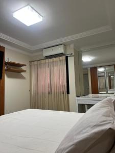 马瑙斯APARTAMENTO EM EDIFICIO 100% MOBILIADO PARA TEMPORADA的卧室配有白色的床和镜子