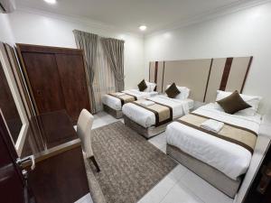 达曼ليالي الشرقية لشقق المخدومة的酒店客房配有两张床和一张书桌