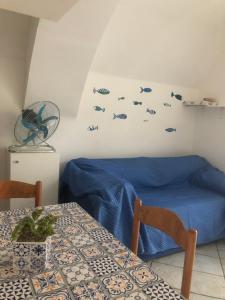 切塔拉La casa a mare的一间设有桌子的房间和一张墙上有鱼的床
