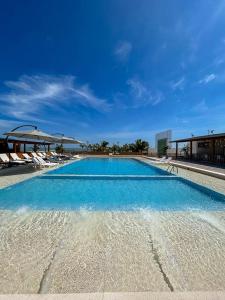 索里托斯Hotel Boutique Caleta Grau的一座蓝色海水和椅子的大型游泳池