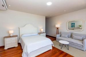 索里托斯Hotel Boutique Caleta Grau的一间卧室配有一张大床和一张沙发