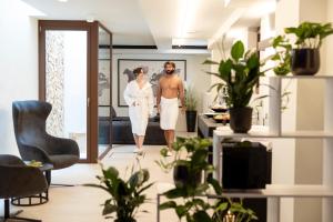 博尔扎诺Wellness Smart Suites的男人和女人穿过一个植物的房间