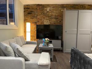 伦敦Cosy Studio Flat with Balcony in Heart of London的客厅设有两张沙发和砖墙
