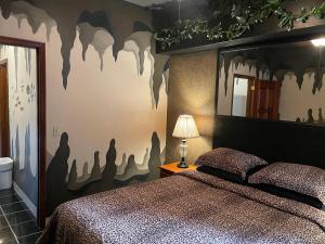 圣佩德罗Belize Budget Suites的一间卧室配有一张床,墙上涂有 ⁇ 蝠