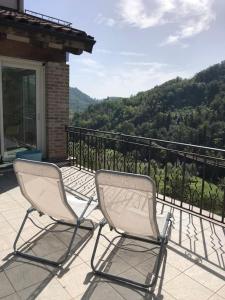 Serralunga di CreaCa' Cuore in Monferrato的两把椅子坐在山景阳台上