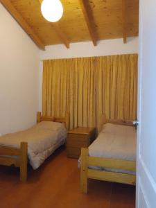 特雷利乌Muy Patagónica, Casa de Campo的一间卧室设有两张床,窗户配有窗帘