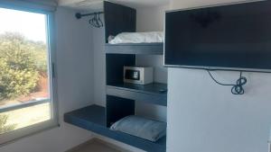 何塞伊格纳西奥Mar y Laguna的一间设有蓝色架子、电视和窗户的客房