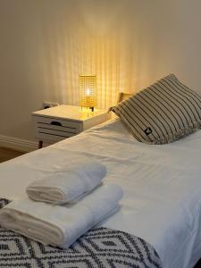 沃特福德Modern Apartment X91 R940的一张带毛巾的床、床头柜和台灯