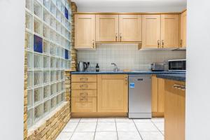 伦敦Central 2Bed Mew in Marylebone的厨房配有木制橱柜和白色洗碗机。