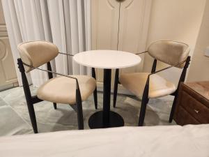 耶路撒冷תבל PRIVATE HOTEL的配有2把椅子和一张桌子的房间