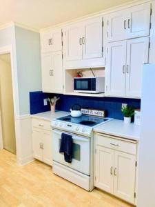 Peoria Speedway Rocky Glen Bradley Park 4bdrm Home的厨房配有白色橱柜和炉灶烤箱。