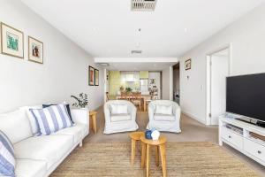 格莱内尔格Waterfront Resort-Style Living at Glenelg Beach的客厅配有白色沙发和电视