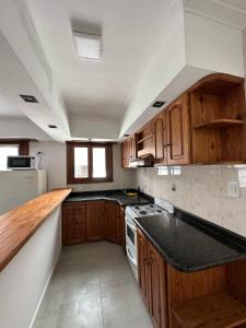 内科切阿Mar y Cielo的厨房配有木制橱柜和黑色台面