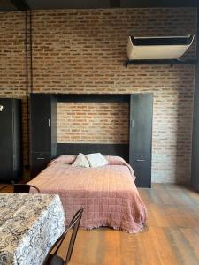 布宜诺斯艾利斯Loft luminoso en Capital Federal的一间卧室设有一张床和砖墙