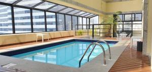 圣保罗The Time Flat - Berrini - 200 metros do WTC的一座大型游泳池,位于一座带窗户的建筑内