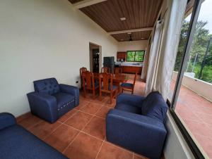 Playa CopelCasa Pura Vida Copal KiteBeach的客厅配有2把蓝色椅子和桌子