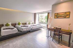 高兰SriLanta Resort and Spa的客房设有两张床和一张书桌