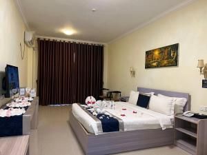 金边City Comfort Hotel Phnom Penh Airport的酒店客房,配有两张带鲜花的床