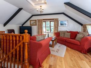 圣大卫Carn Llidi Cottage的客厅配有2张红色沙发和电视