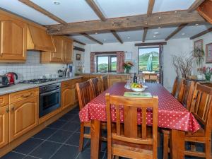 圣大卫Carn Llidi Cottage的厨房配有一张桌子,上面有红色的桌布