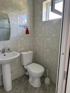 迪利然Sweet Home的浴室配有白色卫生间和盥洗盆。