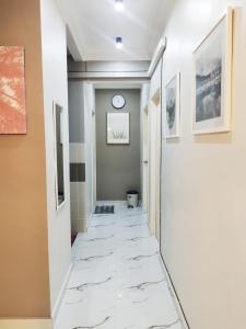 瓜拉丁加奴Mimpi D View Homestay的铺有白色大理石地板的走廊和墙上的时钟