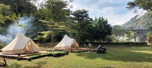 Ban Huai Sok NoiUmarin Glamping Resort的一群在烟 ⁇ 的田野里的帐篷