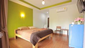 Ban Khao NoiThe shark resort ปราณบุรี的一间卧室配有一张带绿色墙壁的床