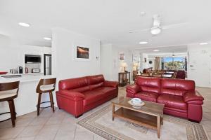 黄金海岸Solnamara - Hosted by Burleigh Letting的客厅配有红色的沙发和桌子