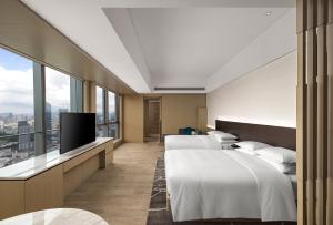 深圳深圳湾万丽酒店的酒店客房设有两张床和一台平面电视。