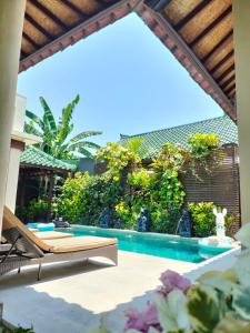 沙努尔素馨花别墅的一个带游泳池和躺椅的庭院