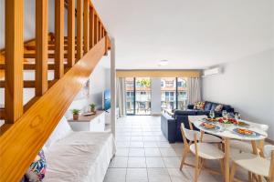尼尔森湾Nelson Bay Breeze Apartment, 29,1 Trafalgar Street - Air conditioned unit with Linen supplied, complex pool and spa的客厅设有楼梯和桌椅
