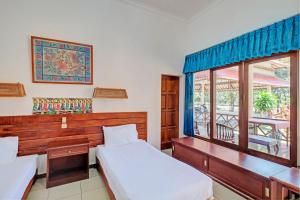 BanyubiruCapital O 93236 Hotel Hapel Negara的一间卧室设有两张床,窗户设有阳台