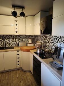 WojtkowaBieszczadzka Sielanka的厨房配有白色橱柜和黑白瓷砖