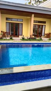 乌布D'Natha Villa Ubud的一座大蓝色游泳池,位于房子前
