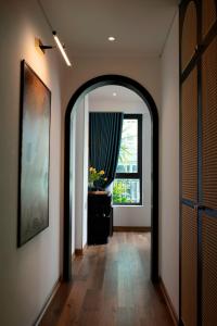 河内Hotel De Rond的走廊上设有拱门,带窗户和镜子