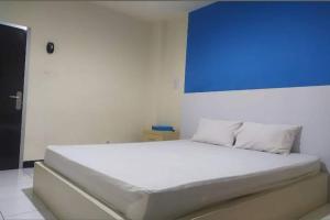 MontongbuwohOYO 93246 Kanditha Homestay的一间卧室配有一张大床,上面有蓝色的板