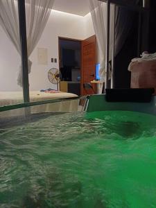 独鲁万Bmf Homestay Jacuzzi的一间位于床边的绿色水池客房