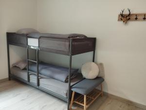 MaarkedalVakantiehuis 't Leideveld的带两张双层床和椅子的房间