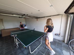 MaarkedalVakantiehuis 't Leideveld的站在乒乓球桌旁的女人