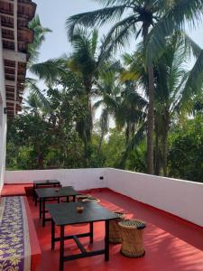 QuerimAdi Shakti Guesthouse的棕榈树阳台的一排桌子