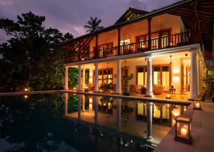 韦利格默Eraeliya Villas & Gardens的夜间带游泳池的别墅