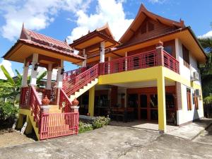 湄宏颂茉莉花度假村的红色和黄色阳台的房子