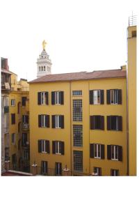 罗马Lexie Suites的黄色建筑,后方有钟楼
