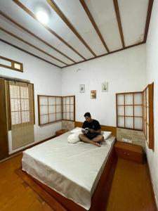 万慈Nua Indah Hotel & Resto Wakatobi的坐在房间里床边的人