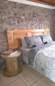 Dinokeng Game ReserveHartbees Boskamp的一间卧室配有一张带木制床头板和一张桌子的床。